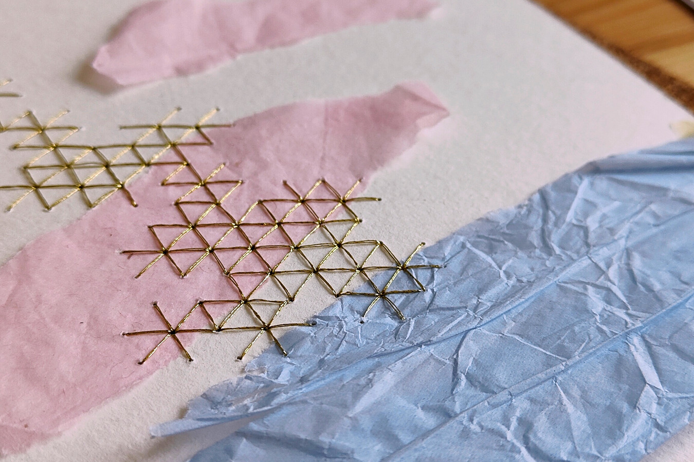 hilos dorados bordado sobre collage de papel blanco, rosa y celeste