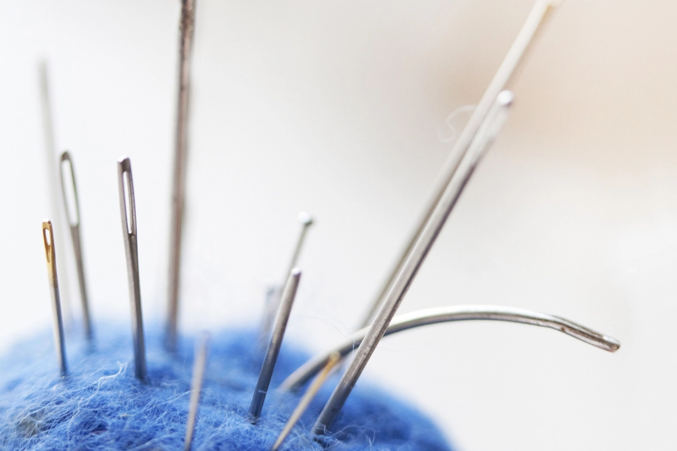 agujas costura y bordado pinchadas en alfiletero o acerico de fieltro azul